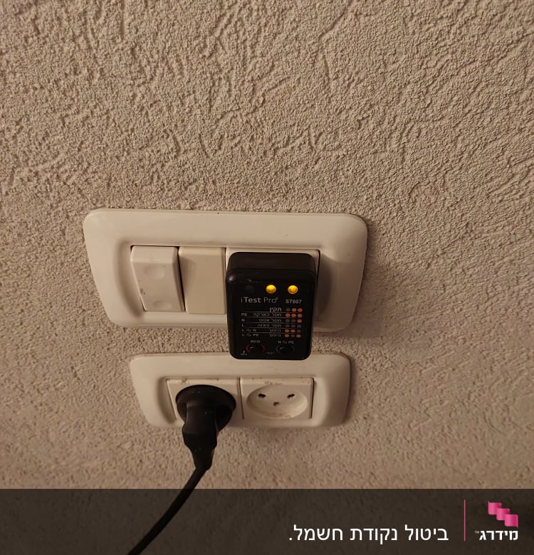 בודק חשמל מחובר לשקע עם נורות דולקות